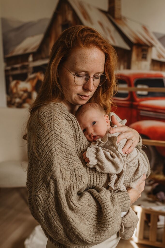 Moeder en kind tijdens een newborn fotoshoot in huis. 