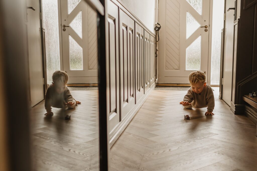 Ouder kind speelt rustig tijdens de newborn shoot in huis