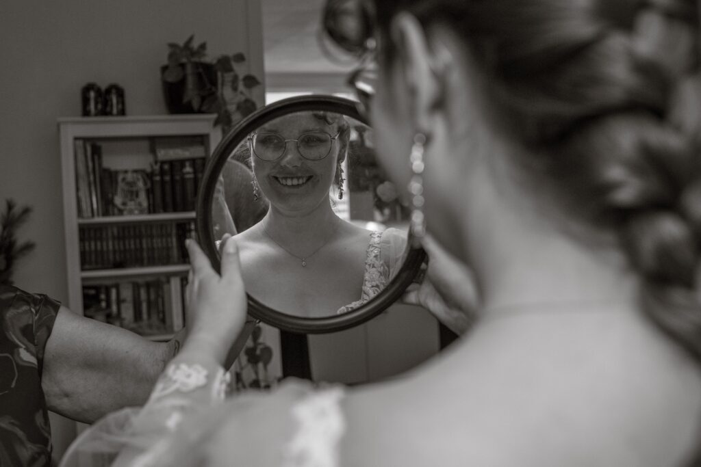 Bruidsfotograaf kosten fotoshoot voor de blog waar de bruid in de spiegel kijkt.