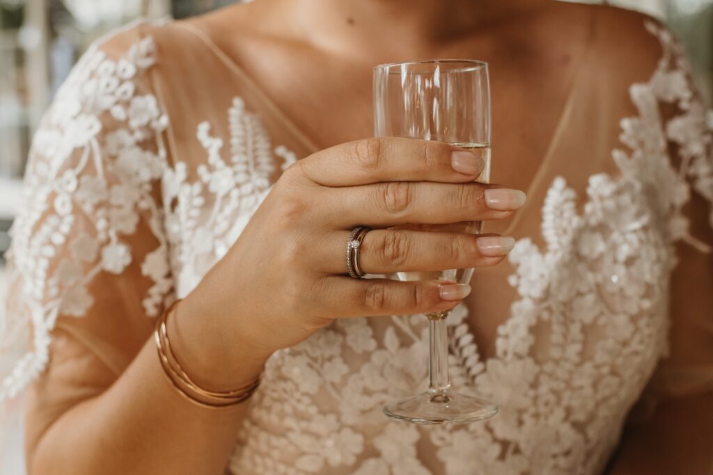 Kosten voor een trouwfotograaf shot waarbij de bruid een glas heft.