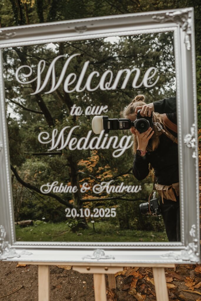 De prijs van een bruidsfotograaf reportage waarbij je de fotograaf ziet in de weerspiegeling van de spiegel.