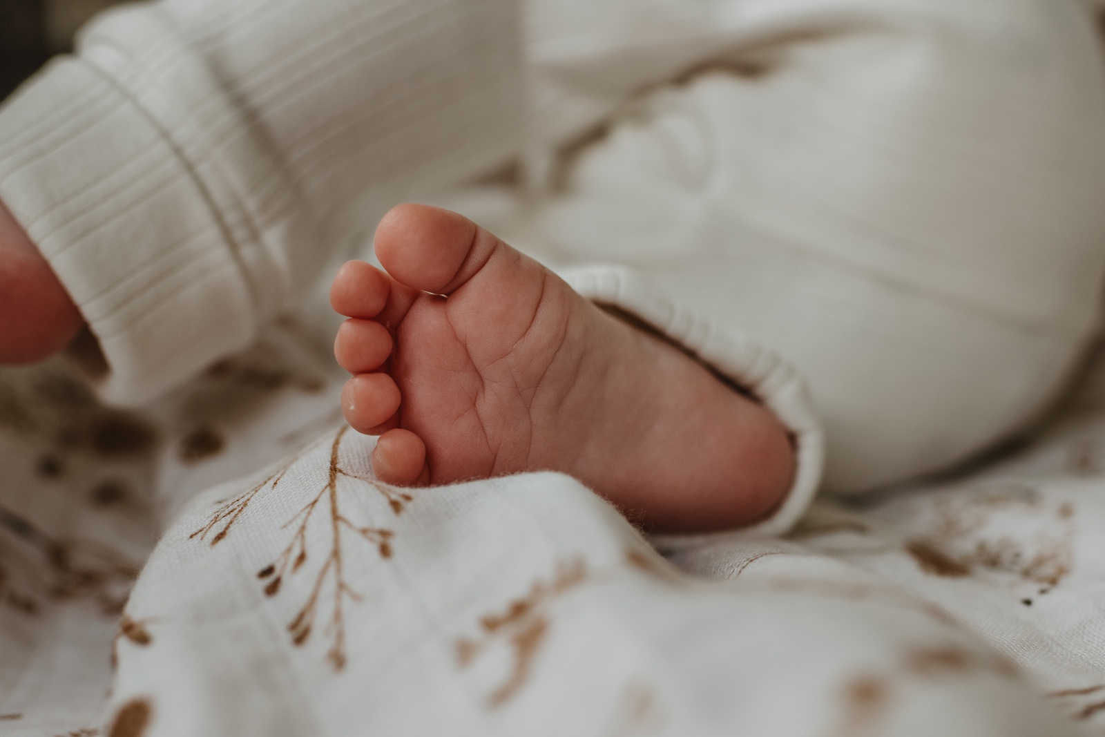 Wanneer een newbornshoot plannen blog header met een baby voetje.